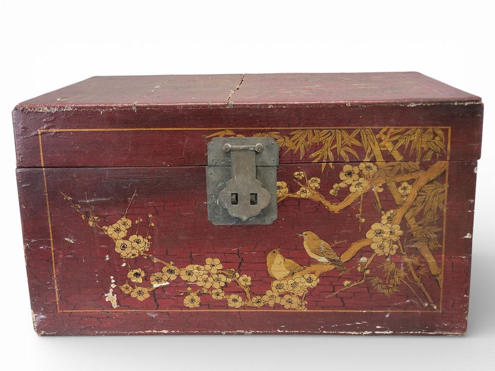 ASIAN RED LACQUERED CHEST: 19th century, wood and plaster. An Oriental red lacquered chest with a gilt scene of birds in flowering branches. With brass handles and latch. 13.5" high, 24" wide, 16" deep. Provenance: Kemp estate,