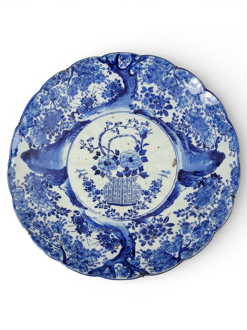 JAPANESE PORCELAIN CHARGER: 19th century. Large charger with blue and white decoration, including a basket at center and a border with trees and flowers. 17.5" diameter. Provenance: an Ohio collection. NOTE: We are happy to answ