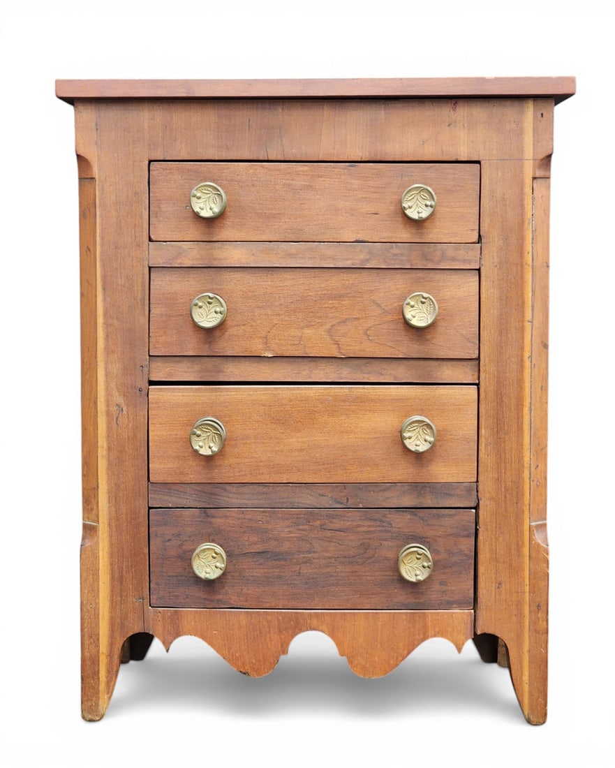 MINIATURE CHEST OF DRAWERS: American, 19th/woth century, cherry and poplar. Four drawers and a shaped skirt; appears to be made from a period tall clock base with added drawers. 24.5" high, 19" wide, 10.25" deep. Provenance: an
