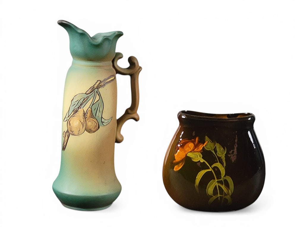 WELLER ART POTTERY: Zanesville, Ohio, early 20th century. Two pieces of Weller art pottery: an ewer with pear decoration and a rococo-style handle, Floretta line, signed by artist Madeline Thompson, 10.5" high, together