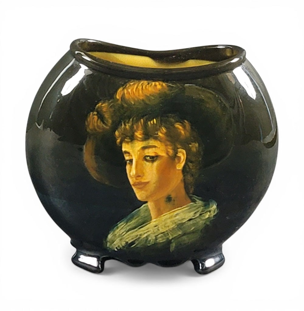 WELLER GIBSON GIRL PORTRAIT PILLOW VASE: Zanesville, Ohio, 1897-1898. A pillow vase with a portrait of a Gibson Girl, first Dickens Ware line. 7" high. Provenance: Collection of Ray and Eva Thomas, Zanesville, Ohio; Purchased from Red