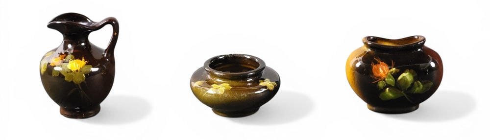 THREE PIECES OF MINIATURE WELLER POTTERY: Zanesville, Ohio, late 19th-early 20th century. Three miniature pieces with floral decoration: two Louwelsa line cabinet vases, a squat form. 2" high, and a pillow-type vase. 3" high; together with a