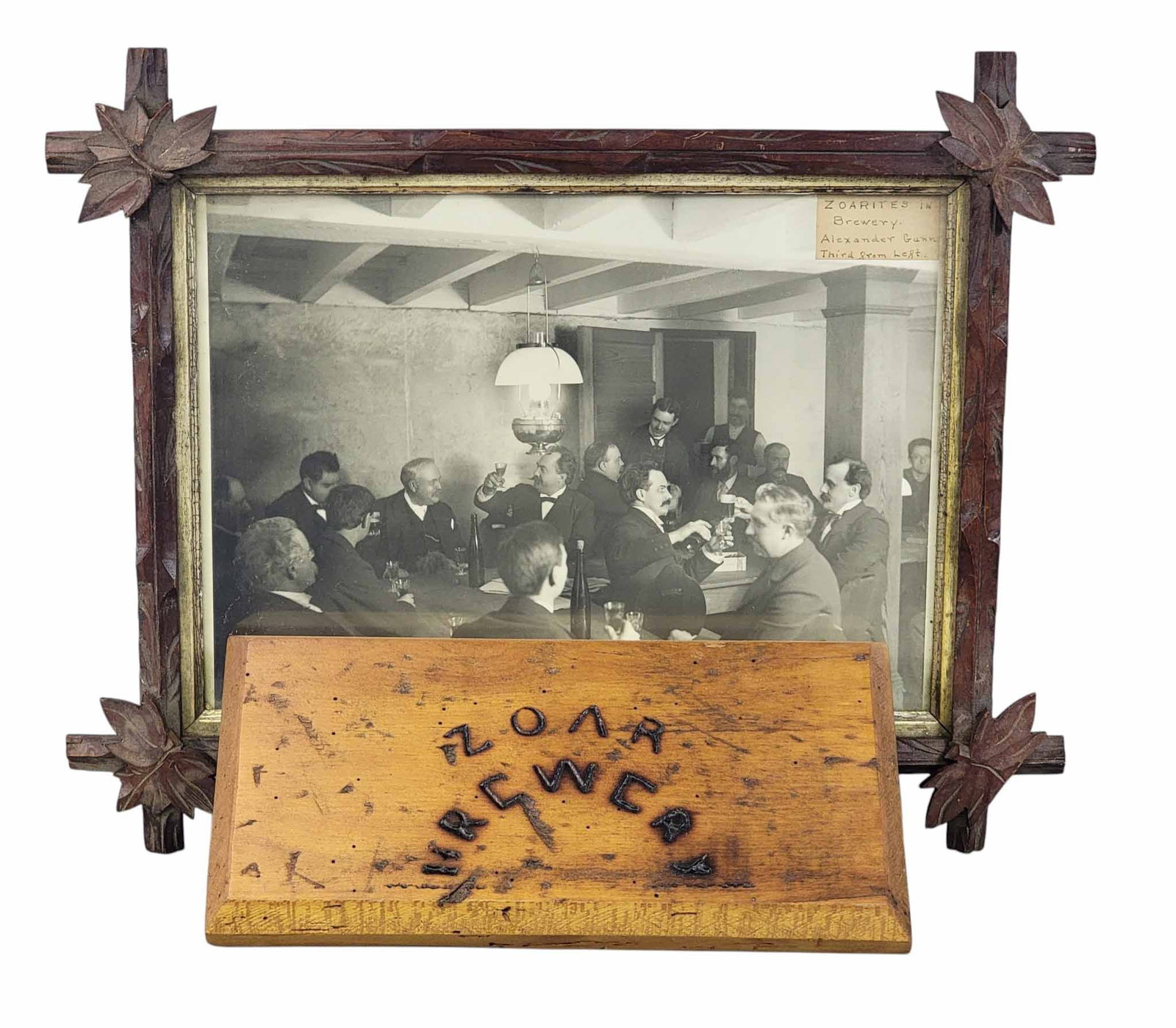 TWO ITEMS FROM THE ZOAR BREWERY: Late 19th century. Includes a photograph of the interior, filled with Zoarites and Alexander Gunn, in a period frame, 15" high, 19" wide (overall); together with a plaque branded with "ZOAR BREWERY,"