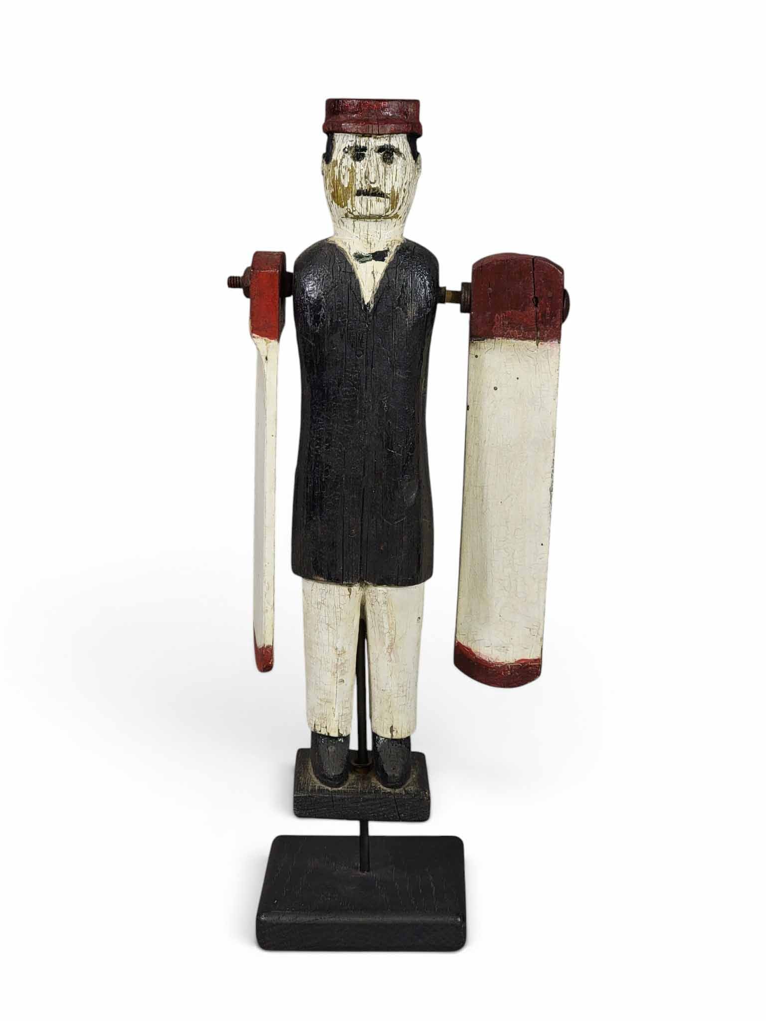 FOLK ART WHIRLIGIG: American, early 20th century. Carved and with original paint, depicting a dapper and mustachioed man wearing a cap. On a modern base. 15.25" high. Provenance: an Ohio collection. NOTE: We are happy to