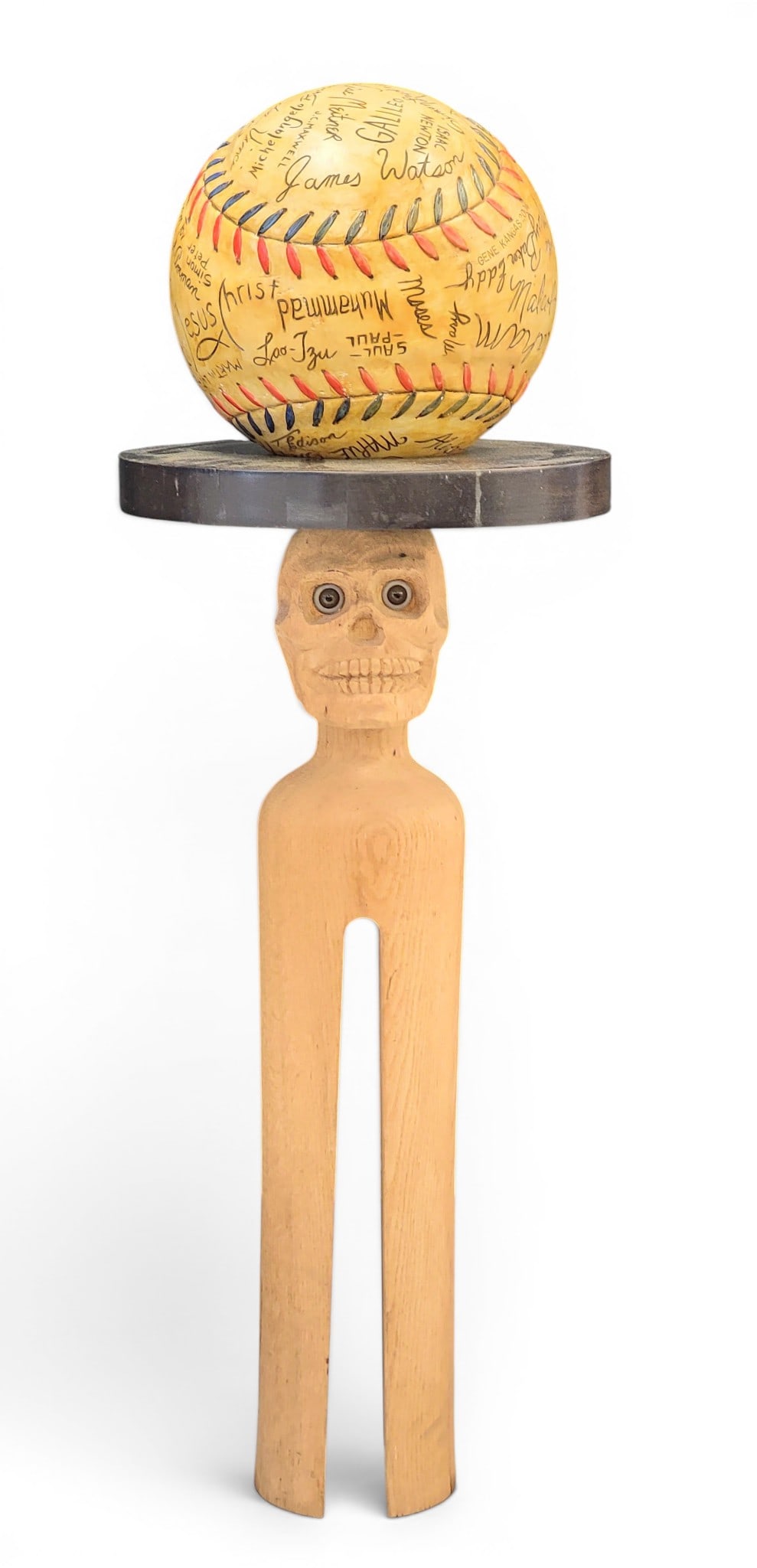 SCULPTURE BY GENE KANGAS (OHIO, B. 1944): Signed and dated 2004. A carved baseball covered in "signatures" (including Picasso, Joseph Smith, Jesus, Malcolm X, among others), that sits on a table, the base in the form of a large clothespin wit
