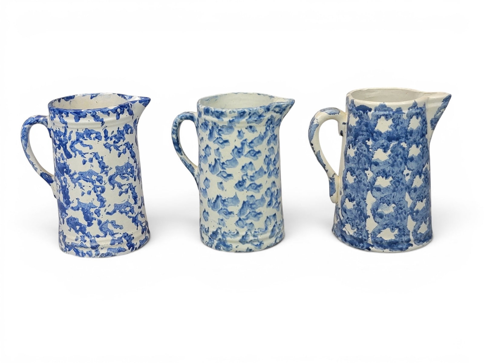 COLLECTION OF "KITCHEN" STONEWARE: Indiana and Ohio, early 20th century. Includes three Ohio blue spongeware pitchers, 9" high each; together with a nested set of 5 "new old stock" bowls by Clay City Pottery, Clay City, Indiana, with a