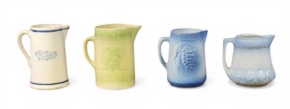 FOUR STONEWARE PITCHERS: American, early 20th century. Three molded pitchers, one with Dutch windmill scene, and various glazes. Tallest is 9" high. Provenance: an Ohio collection. NOTE: We are happy to answer questions and