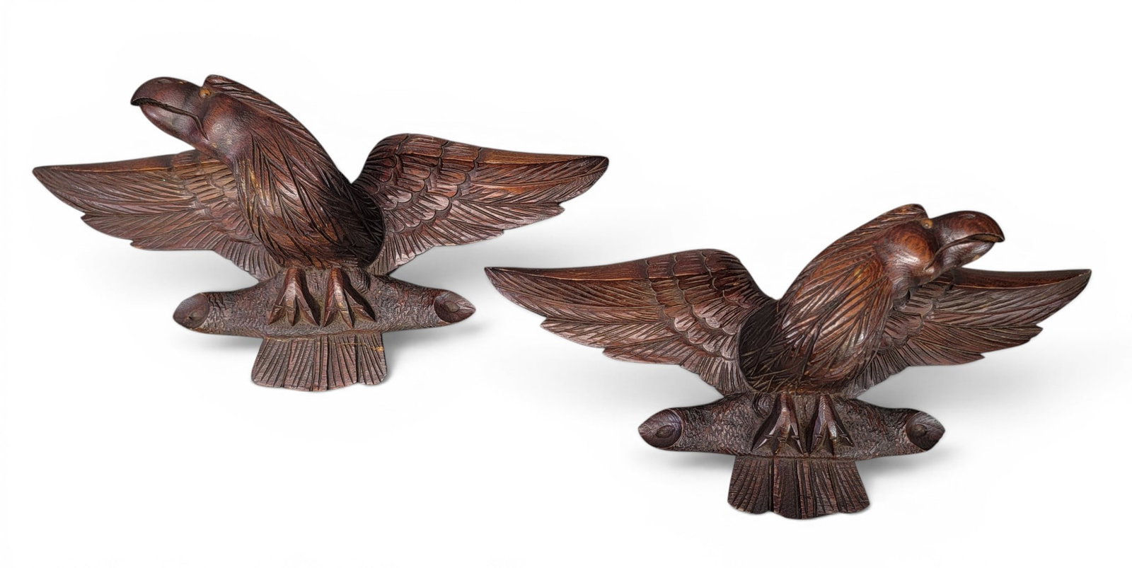 PAIR OF CARVED EAGLES: American, late 19th century, possibly chestnut. Spread-winged eagles perched on branches, nicely carved, and with inset glass eyes. 8" high, 19" wide. Provenance: an Ohio collection. NOTE: We are