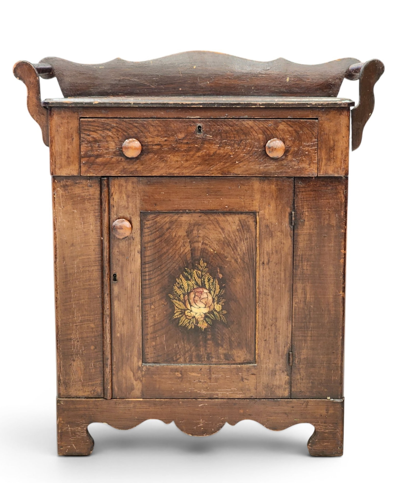 DECORATED WASHSTAND: American, 3rd quarter-19th century, pine. Gallery over one drawer and one door, on a shaped base, and with its original stenciled decoration on a grain-painted ground. 32.5" high, 28.5" wide, 15.5" de