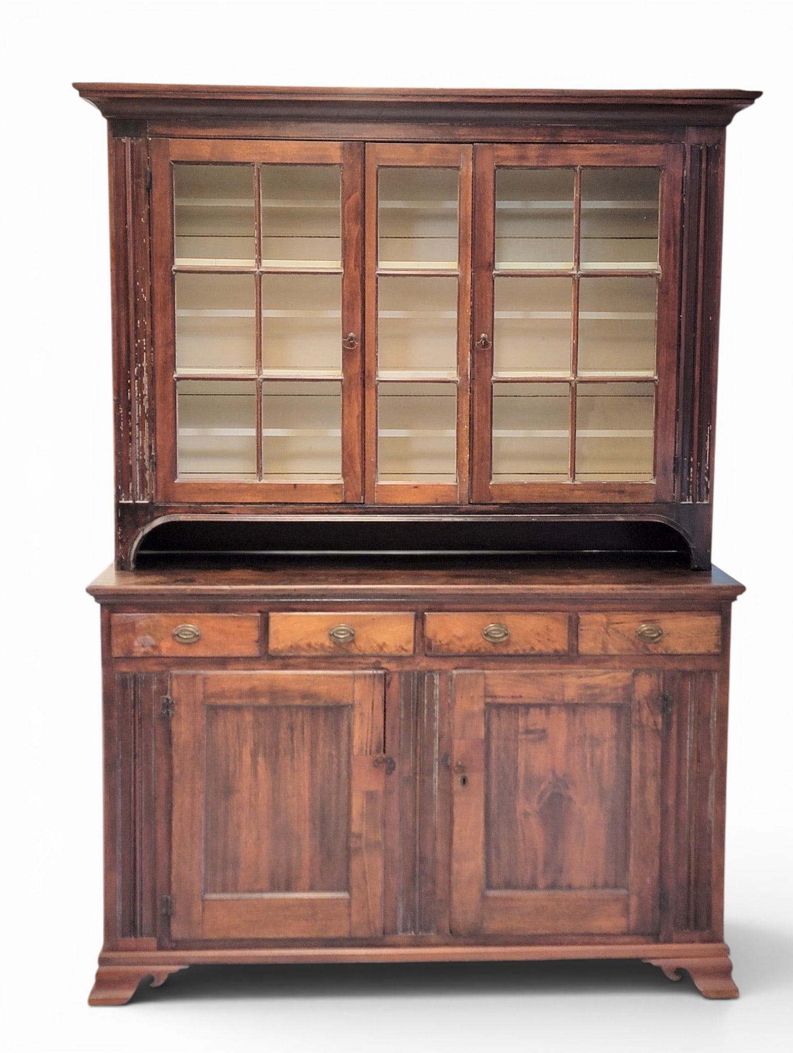 PENNSYLVANIA STEP-BACK CUPBOARD: 1815-1830, walnut and pine. Two-piece construction, the upper section with two 6-pane doors and a central 3-pane panel, the lower section with four drawers over two doors, all flanked by molded