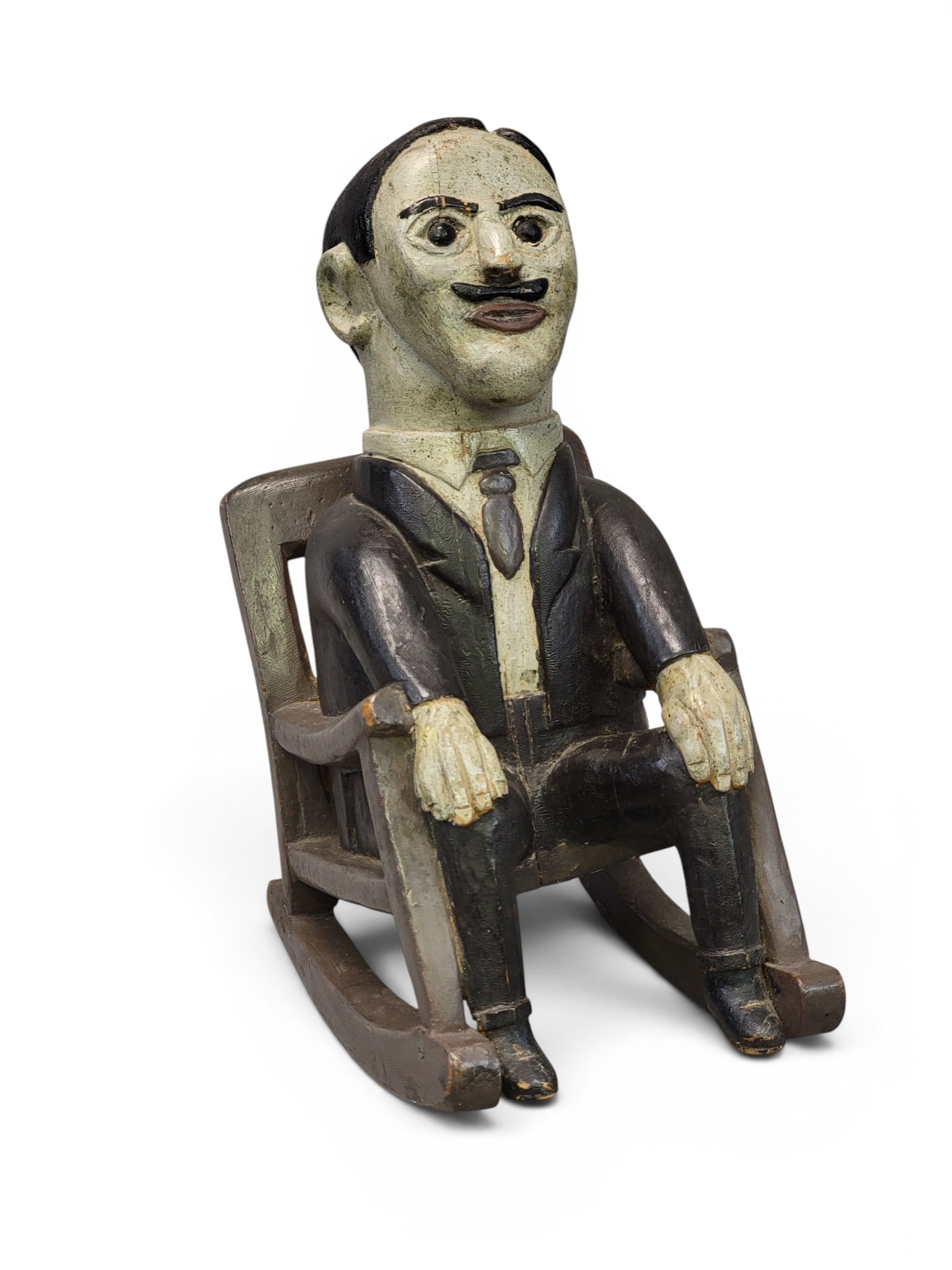 FOLKSY CARVED AND PAINTED FIGURE: Early 20th century. A dapper gentleman seated in a rocking chair, and retaining its original paint. 10.5" high. Provenance: a Pennsylvania collection. NOTE: We are happy to answer questions and take