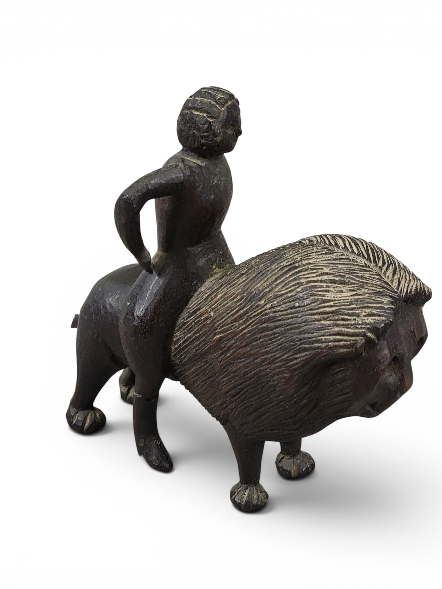 THREE FOLK ART CARVINGS: Late 19th-early 20th century. Includes a walnut blotter with recumbent lion, 9" long; together with a pipe bowl with squirrel, 5" long, and a stylized carving of a woman riding on the back of a smilin