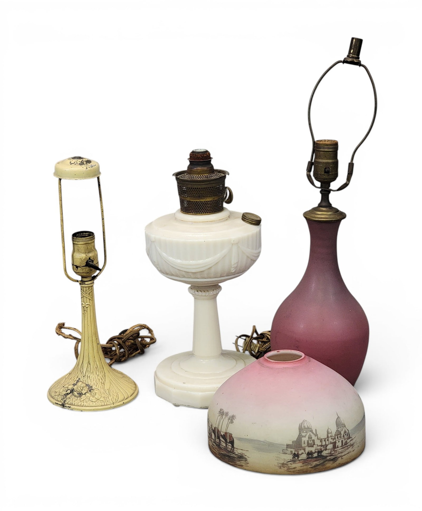 THREE LAMPS: Includes an Aladdin Lincoln Drape oil lamp, 13.5" high; together with a Clement Hull for Van Briggle art pottery lamp, 20" high (including harp); and a painted lamp with Middle Eastern-themed glass sh