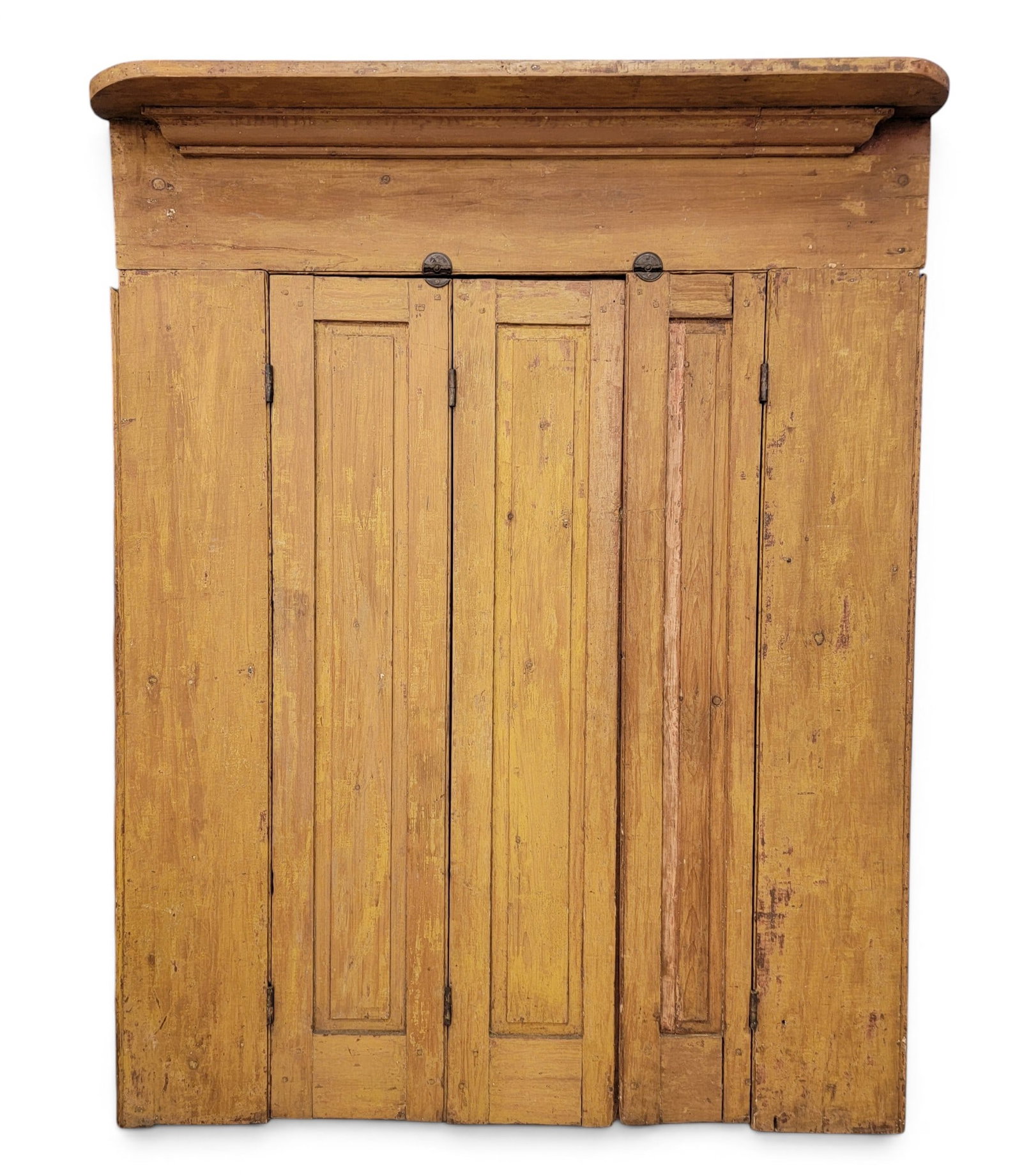 PAINTED FIREPLACE SURROUND: Attributed to Virginia, mid-19th century, pine. High mantel over folding doors, and with its original mustard yellow paint. 69.25" high, 54.25" wide, 7.25" deep; opening is 57.75" by 33". Provenance: