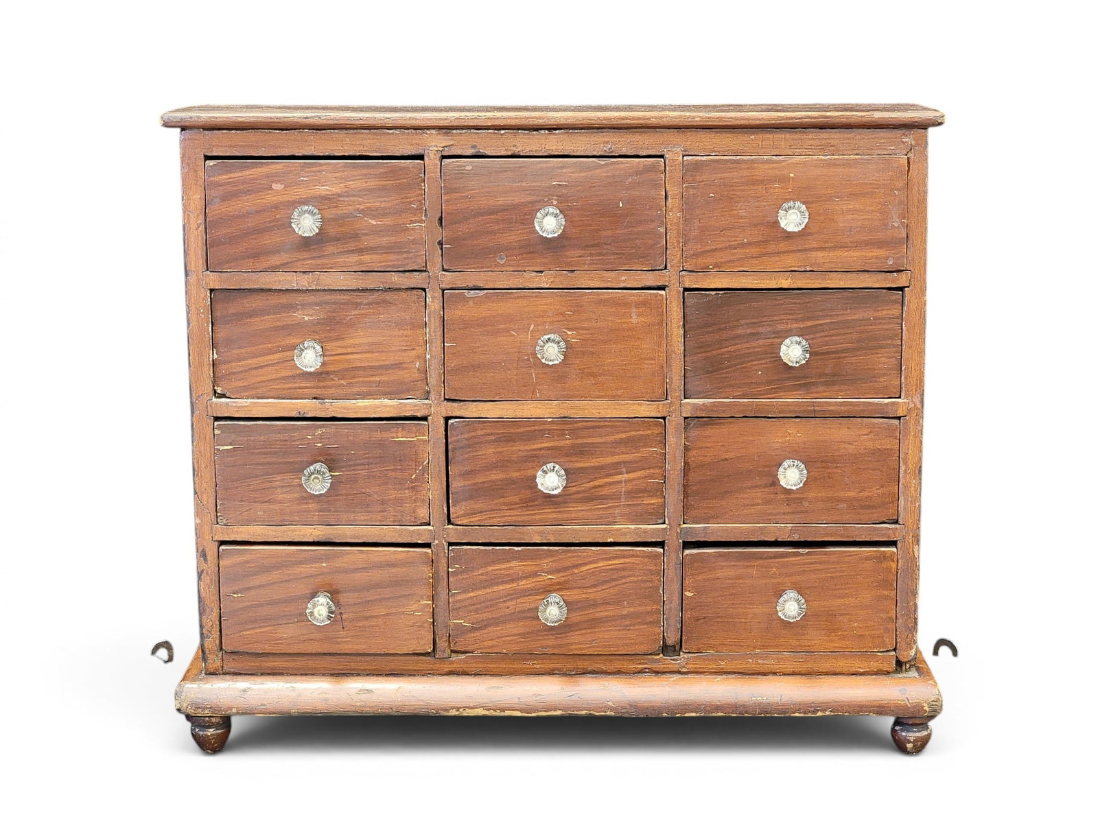 APOTHECARY OR SEED CHEST: American, mid-19th century, poplar. Twelve drawers, turned feet, and its original grain-painted decoration. 18" high, 20.5" wide, 7.5" deep. Provenance: an Ohio collection. NOTE: We are happy to