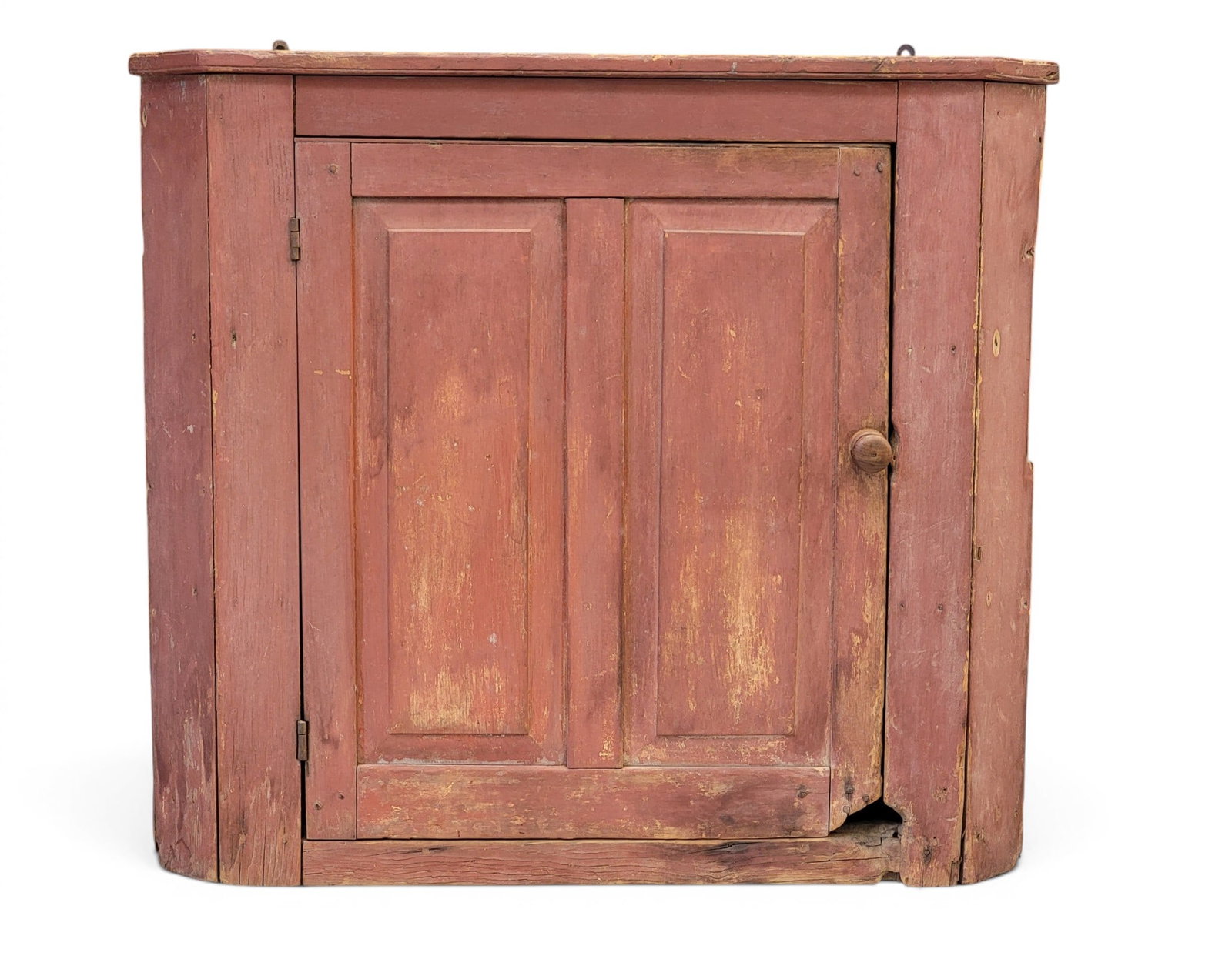 HANGING CORNER CUPBOARD: American, 19th century, pine. Paneled door and early red paint. 31" high, 34.5" wide, 14" deep. Provenance: an Ohio collection. NOTE: We are happy to answer questions and take additional photos of