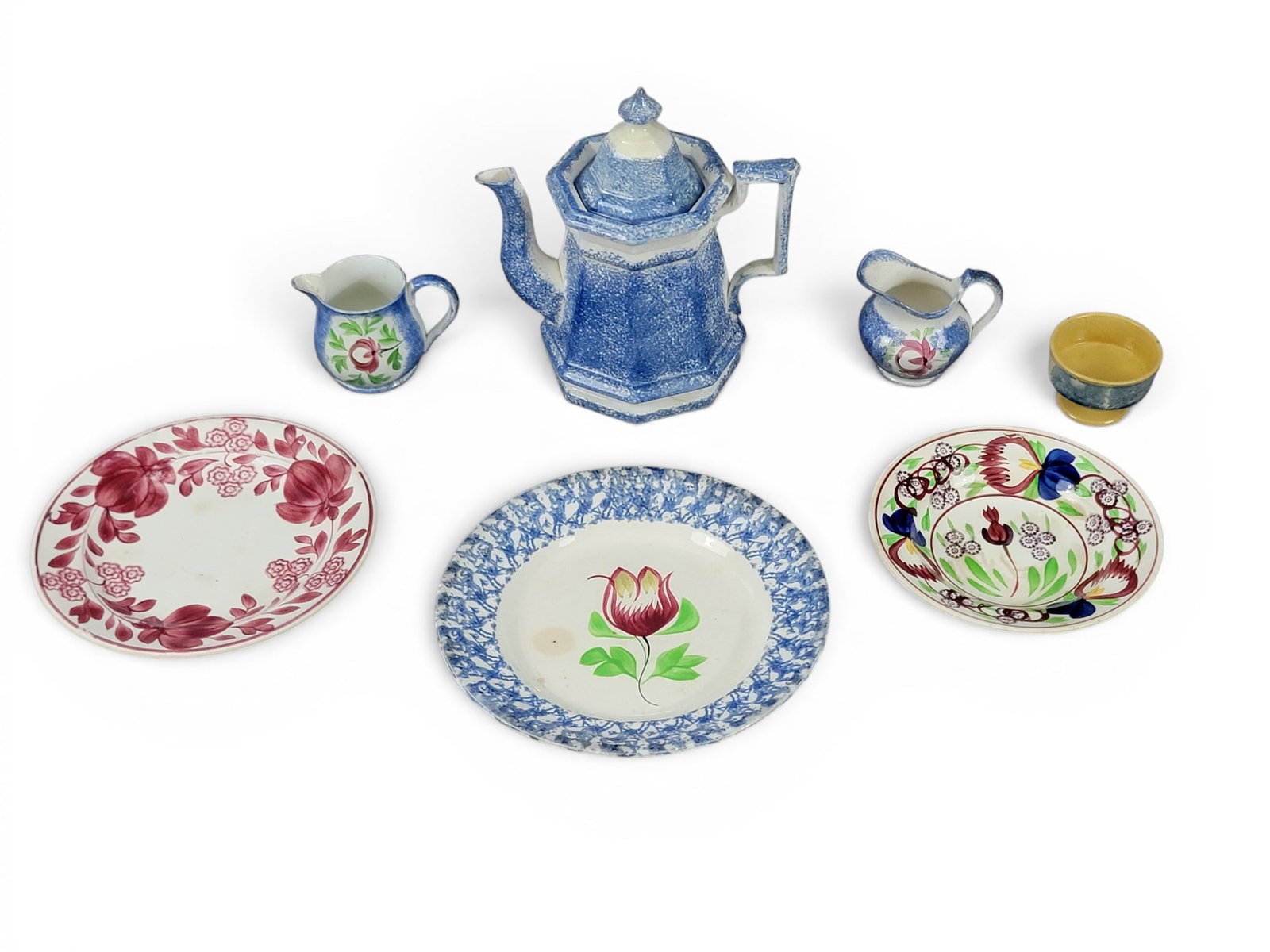 COLLECTION OF COLORFUL CERAMICS: 19th century. Includes blue spatter ware, Adams rose, stick spatter, and mocha/dendritic decorated yellow ware. Spatter teapot is 9" high. Provenance: a Wisconsin collection. NOTE: We are happy to