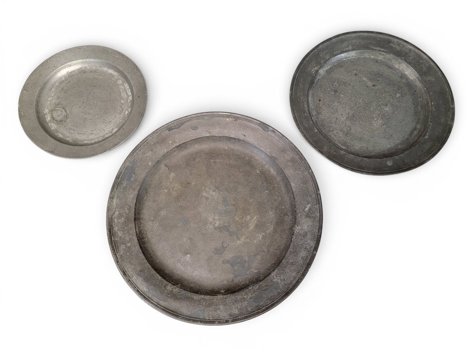 THREE PEWTER CHARGERS: European, 18th-19th century, The smallest marked "RC" with crowns, 13" diameter; the others unmarked, 16.5" and 20" diameter. Provenance: an Ohio collection. NOTE: We are happy to answer questions
