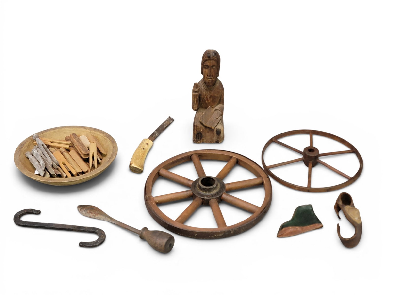 COLLECTION OF FOLKSY ITEMS: 19th-20th century. Includes a carved figure (probably Jesus or an apostle), two wheels, a turned bowl filled with vintage clothespins, a leather boot-shaped coin purse, and a collection of tools.