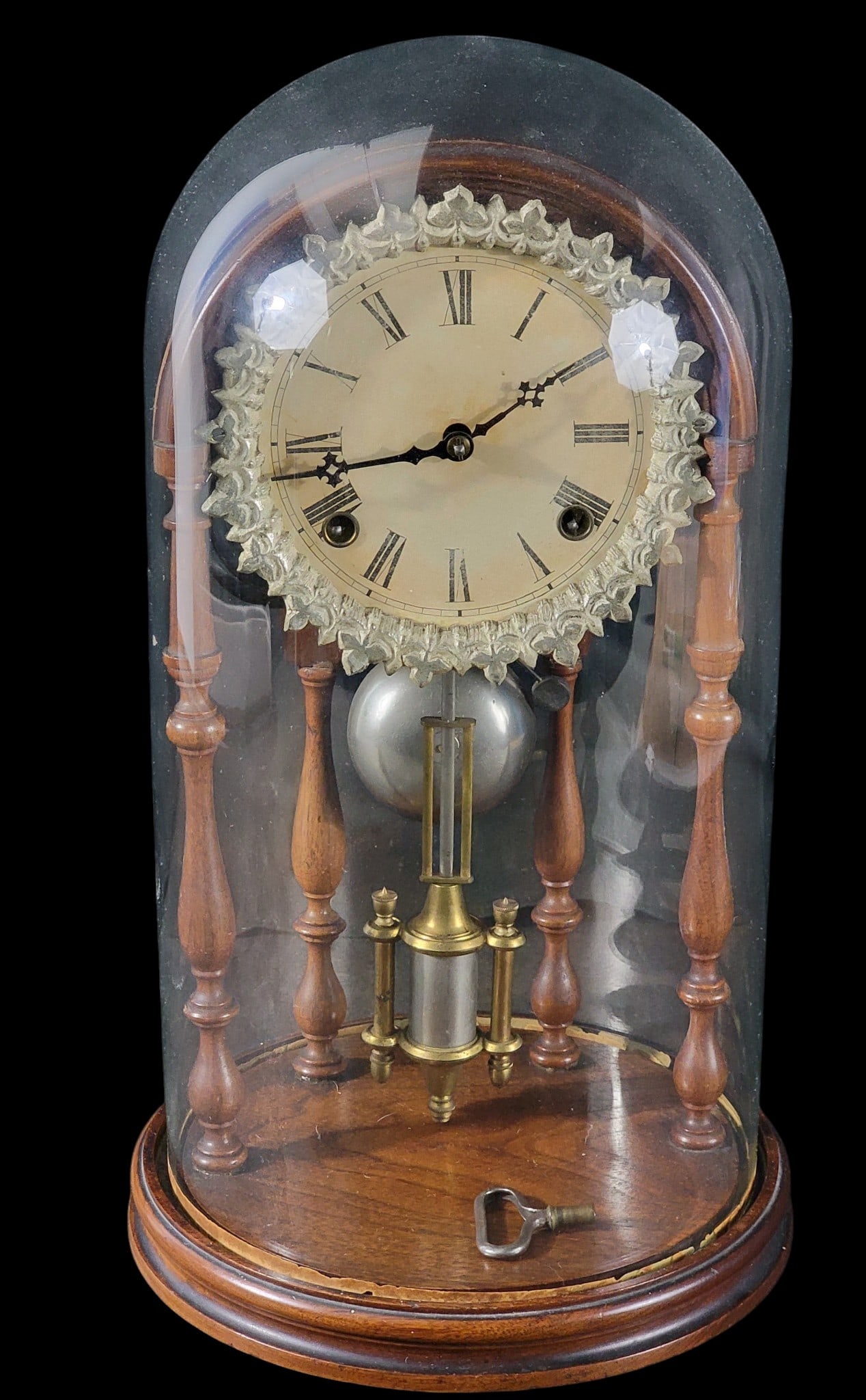 E.N. WELCH CRYSTAL PALACE MANTEL CLOCK: Forestville, Connecticut, late 19th century. Walnut spindles and base, brass movement, paper dial with silvered bezel, and glass dome. 18" high. Provenance: from the collection of Diane Whyte Miller (