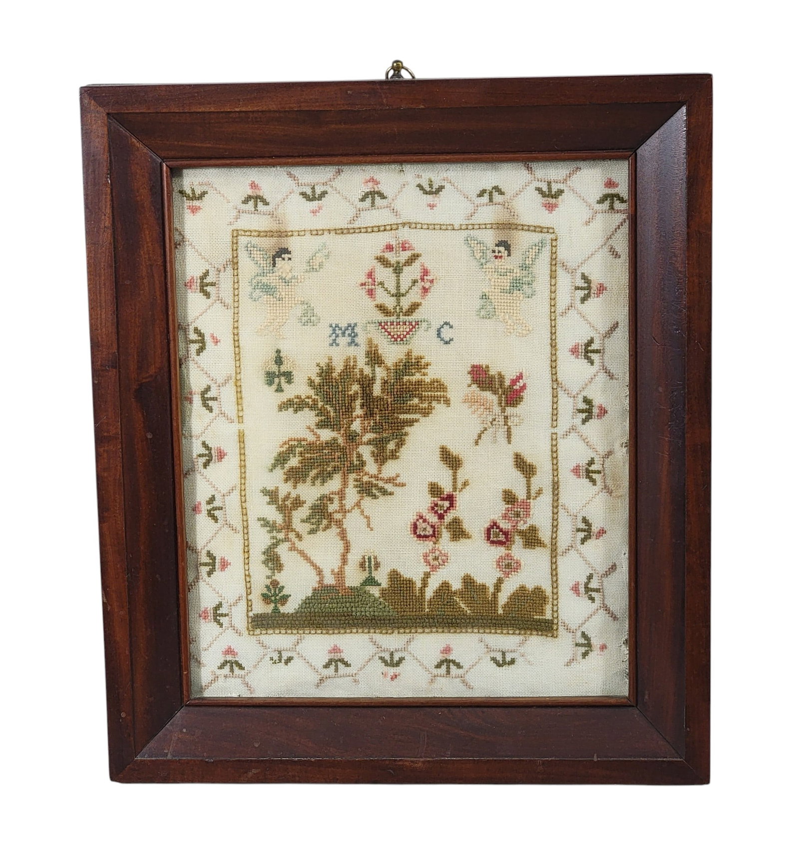 SCHOOLGIRL SAMPLER: American, 19th century, wool on linen. "MC" at center with landscape and angels, and with a floral border. In a period frame, 16" high, 13.75" wide (overall). Provenance: from the collection of Diane 