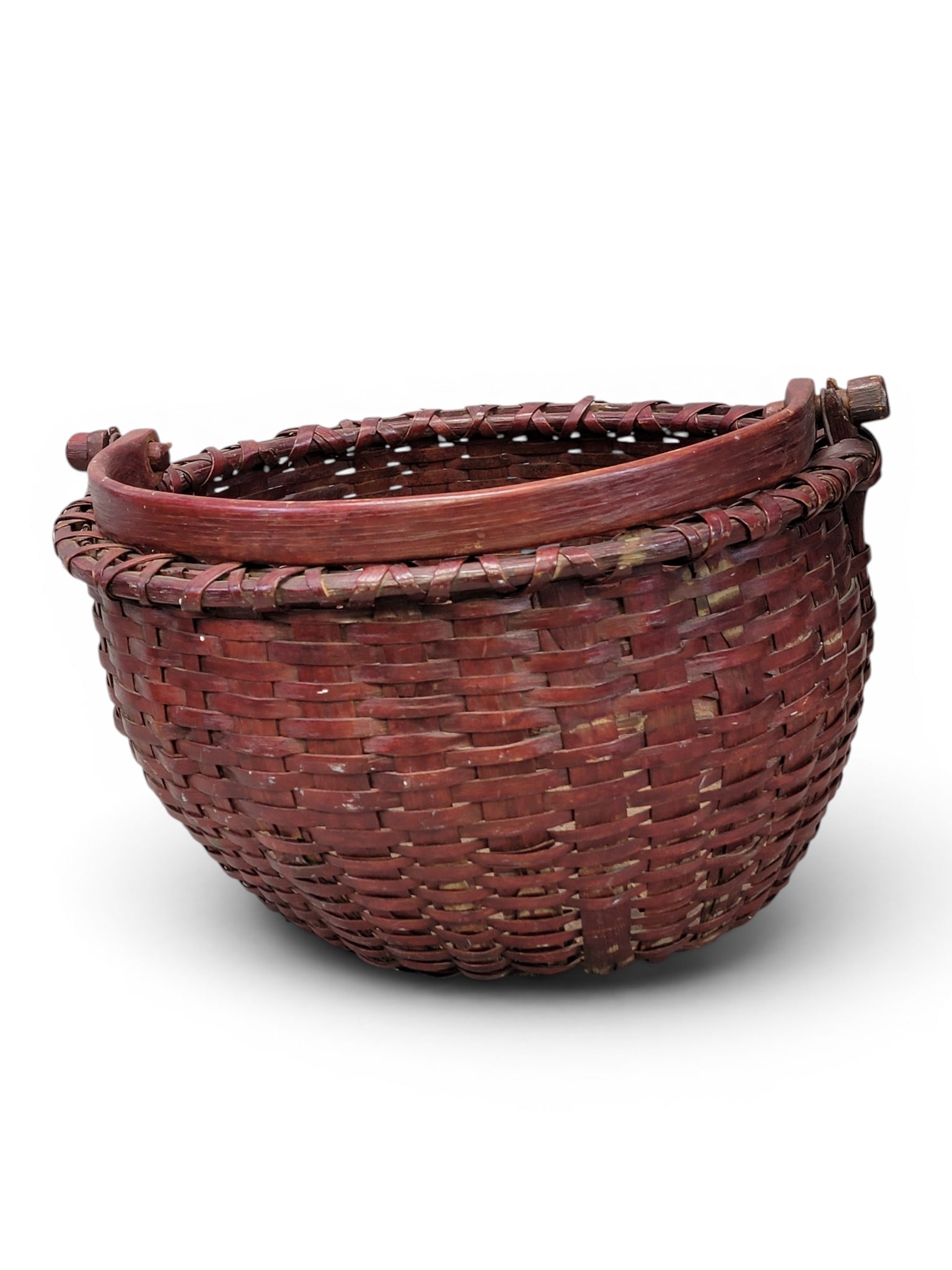 TWO BASKETS: American, 19th century. Includes a handled basket with old red paint and wooden bottom, 18.25" diameter; together with a round basket with carved loop handles, 15" diameter. Provenance: from the