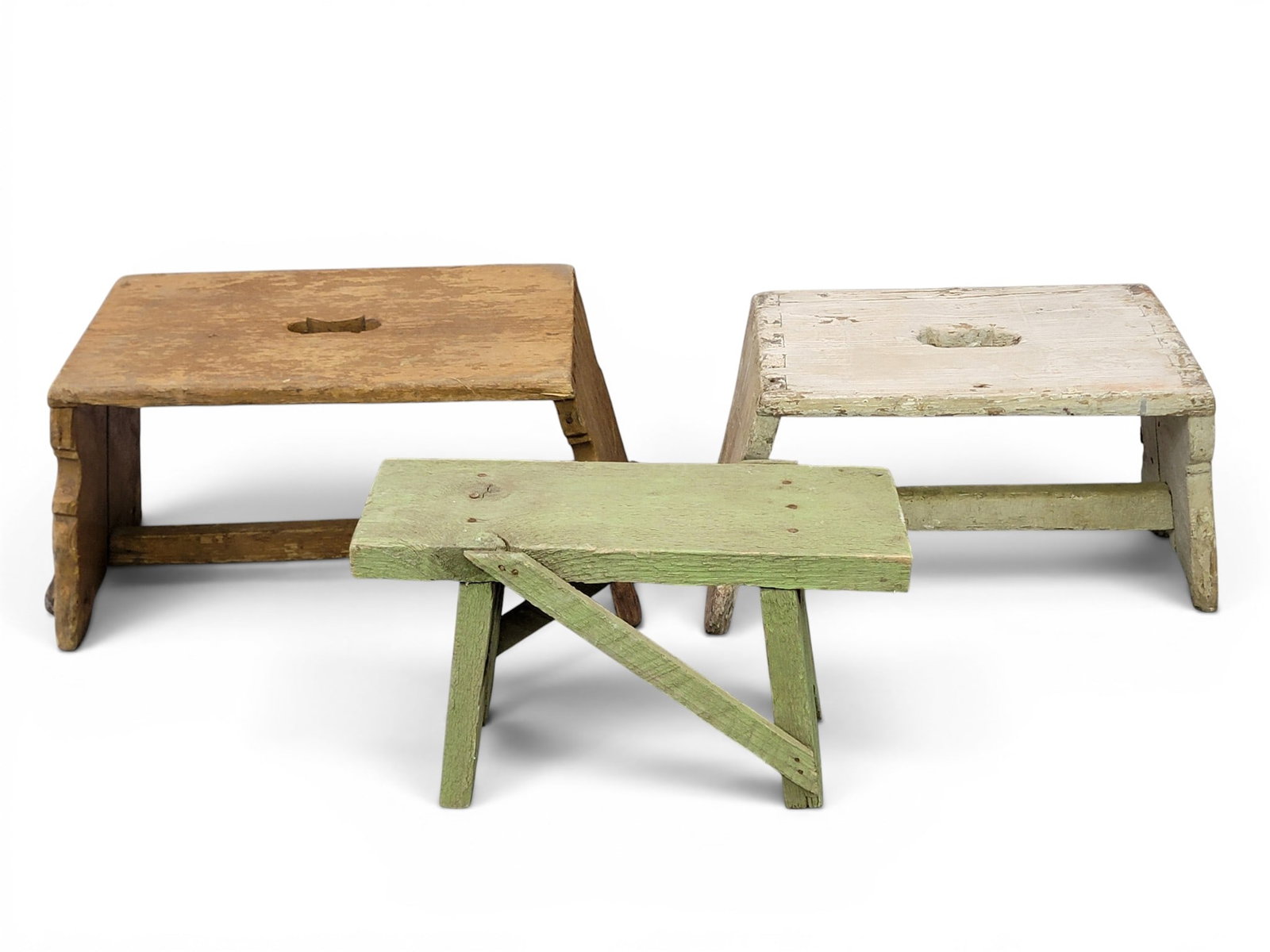 THREE PAINTED STOOLS: 19th century. Two are dovetailed, all are in old paint. 14" to 16.5" long each. Provenance: a Kentucky collection. NOTE: We are happy to answer questions and take additional photos of lots prior to th