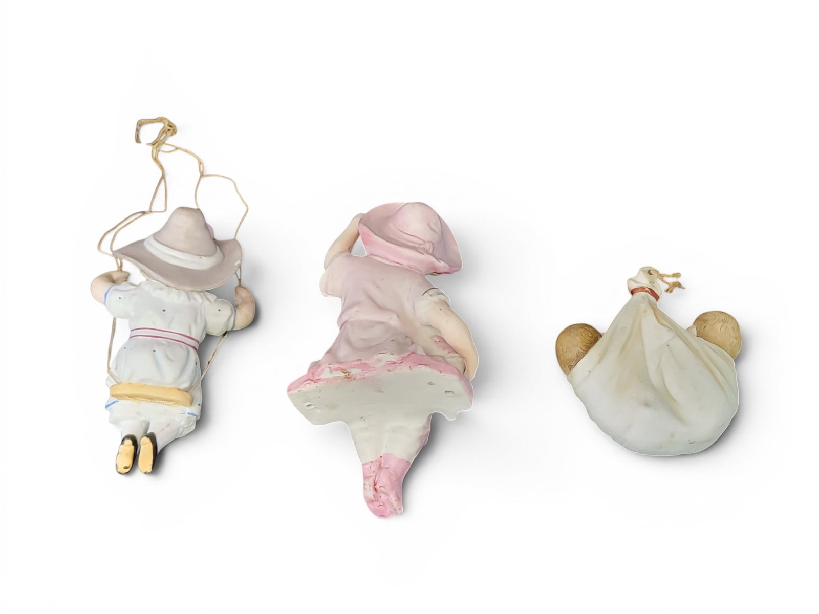 THREE VICTORIAN LAMPS SWINGERS: American, late 19th century, bisque. Includes two young girls and one pair of twin babies. 3.5" to 6" high. Provenance: a northeast Ohio collection. NOTE: We are happy to answer questions and take add