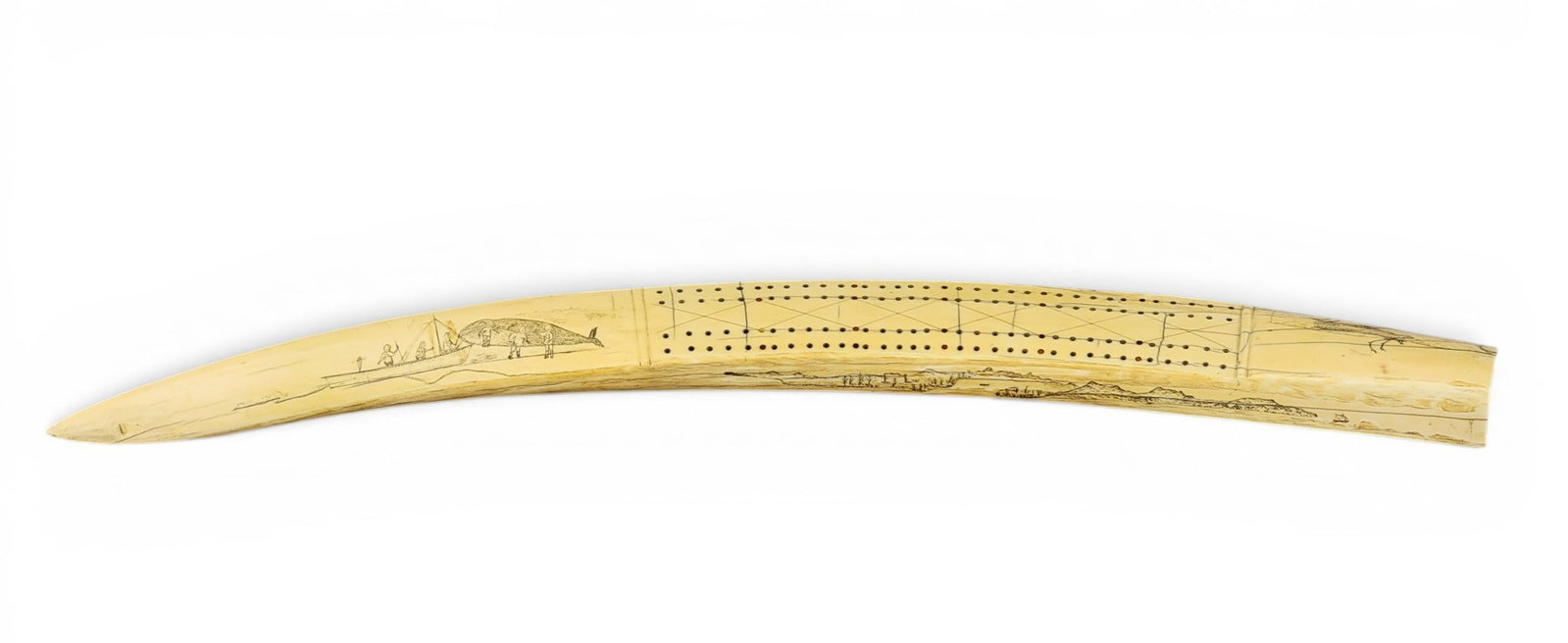 INUIT OR INUPIAQ CRIBBAGE BOARD: Alaska, 1st half-20th century, walrus tusk. The front side with a caribou and a whaling scene; the back side with a village and a seal hunt. 23.75" long. NOTE: this item cannot be shipped