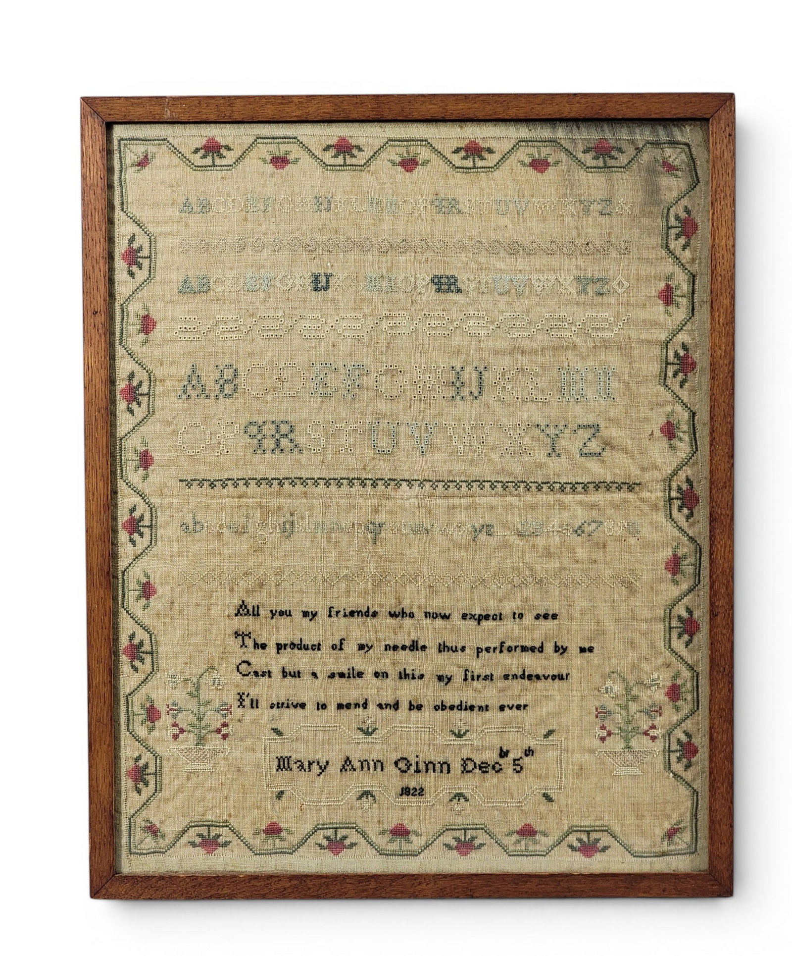 ENGLISH SCHOOLGIRL SAMPLER: Mary Ann Ginn, 1822, silk on linen. With alphabet and number lines, verse, and "Mary Ann Gin Decbr 5th 1822," and with a strawberry border. In a later frame.15.25" high, 12.5" wide (overall).