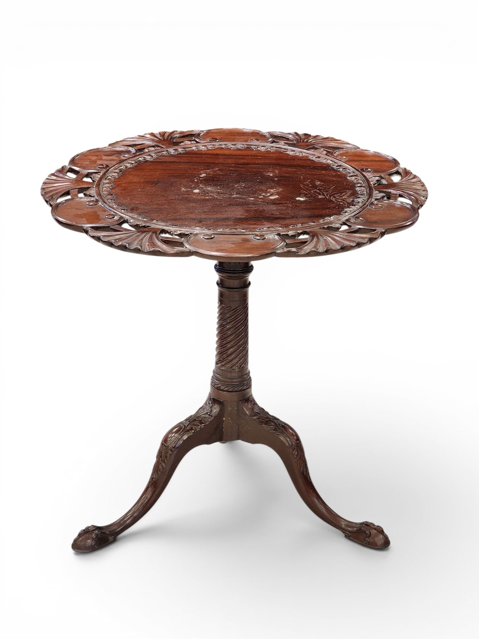 CARVED CHIPPENDALE-STYLE TILT-TOP TEA TABLE: 19th century, mahogany. Elaborately carved top with openwork edge, spiral-turned column, and carved cabriole legs ending in ball and claw feet. 28.5" high, 29" diameter. Provenance: Collection of Bob