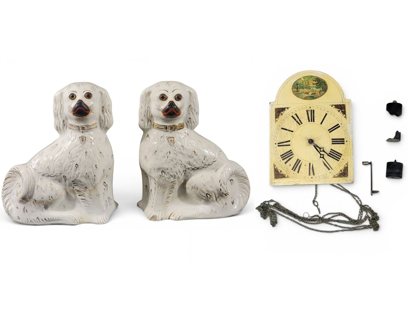 MINIATURE WAG-ON-THE-WALL CLOCK AND PAIR OF STAFFORDSHIRE SPANIELS: German and English, 19th century. The clock with landscape-painted dial, 11" high, 7.75" wide; and the dogs with simple decoration, 12.5" high. Provenance: Collection of Bob and Maxine Edwards, New