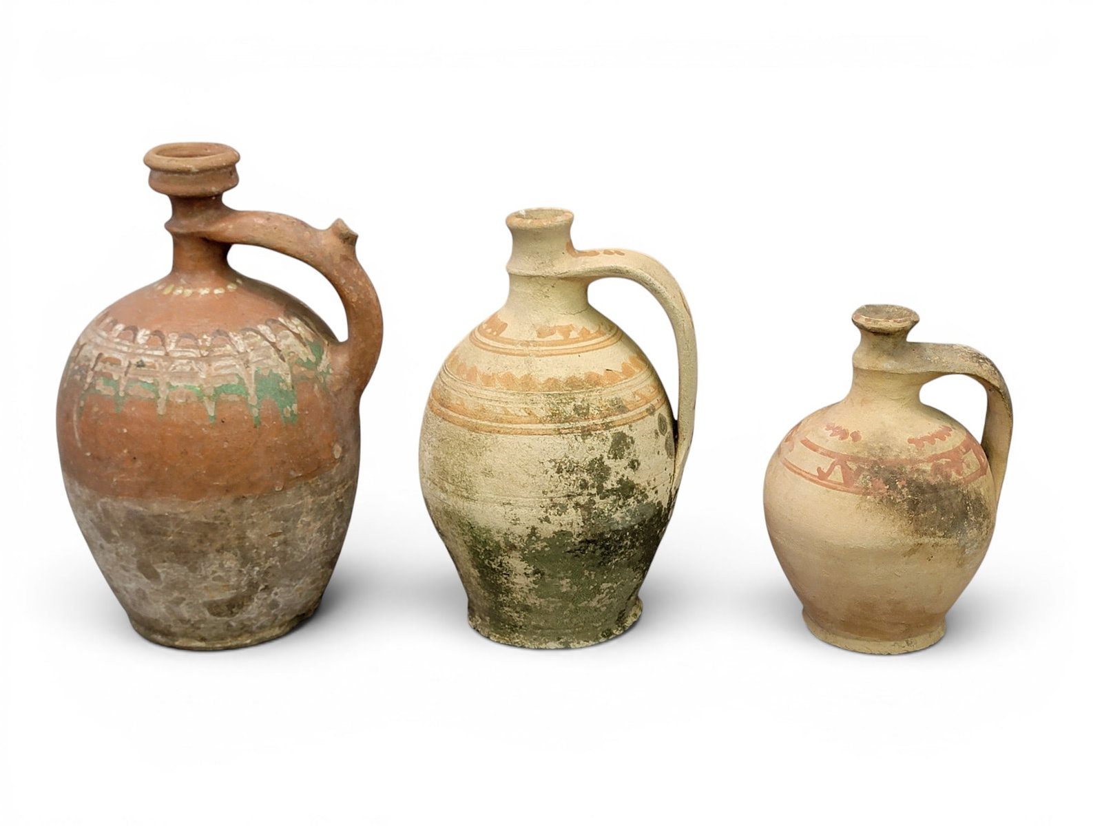 THREE REDWARE JUGS: European, 20th century. Narrow spouts with drizzled and brushed decoration. 8" to 12" high. Provenance: a Kentucky collection. NOTE: We are happy to answer questions and take additional photos of