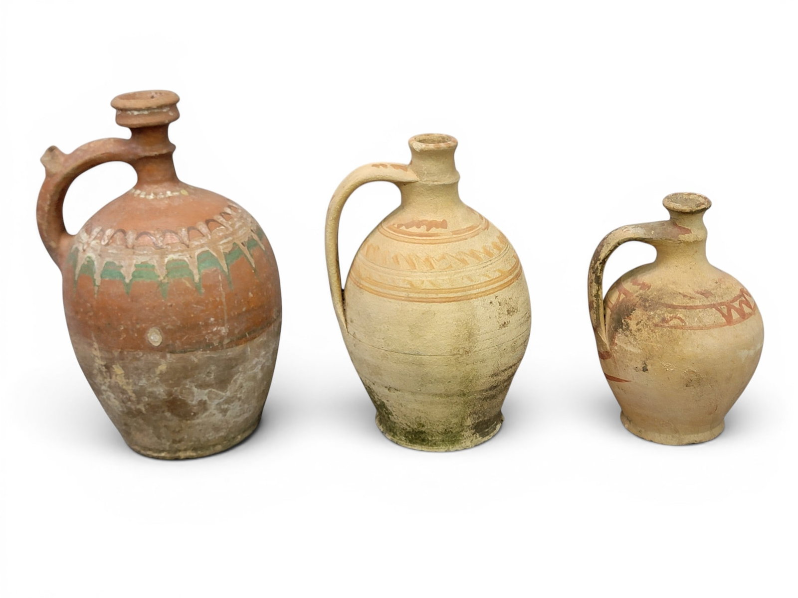 THREE REDWARE JUGS: European, 20th century. Narrow spouts with drizzled and brushed decoration. 8" to 12" high. Provenance: a Kentucky collection. NOTE: We are happy to answer questions and take additional photos of lots