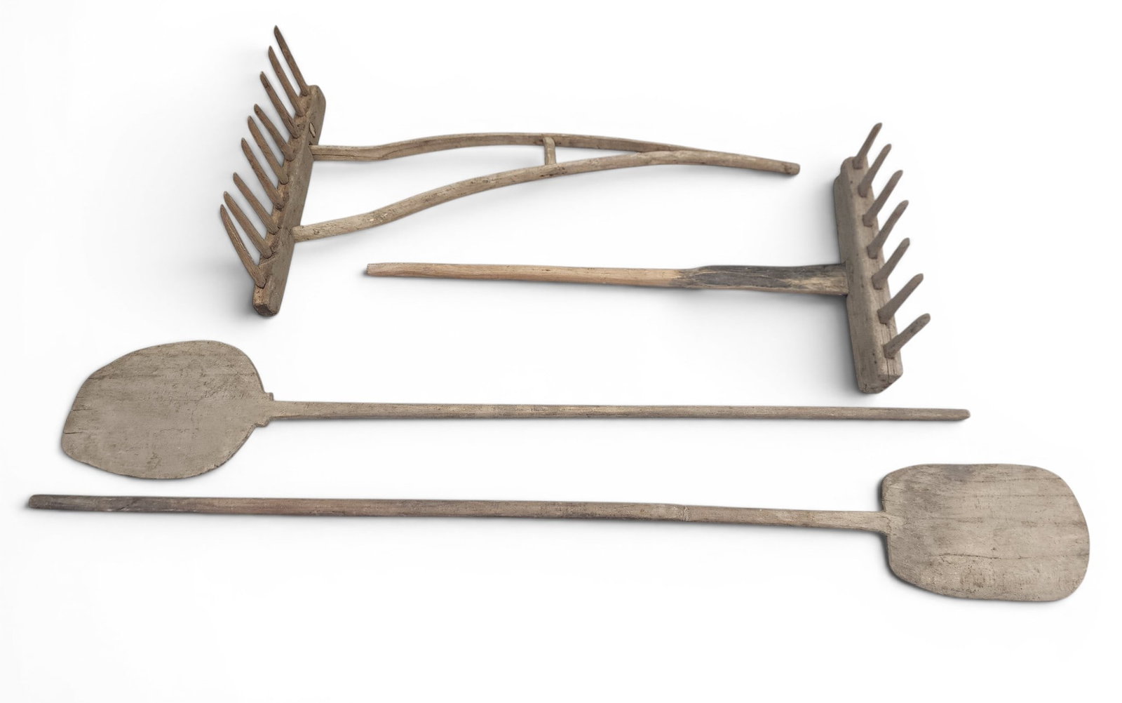 TWO BAKER'S PADDLES & TWO RAKES: 20th century, wood. Includes two long-handled baker's paddles, 81" and 88" long; together with two wooden rakes, 55" and 50" long. Provenance: a Kentucky collection. NOTE: We are happy to answer