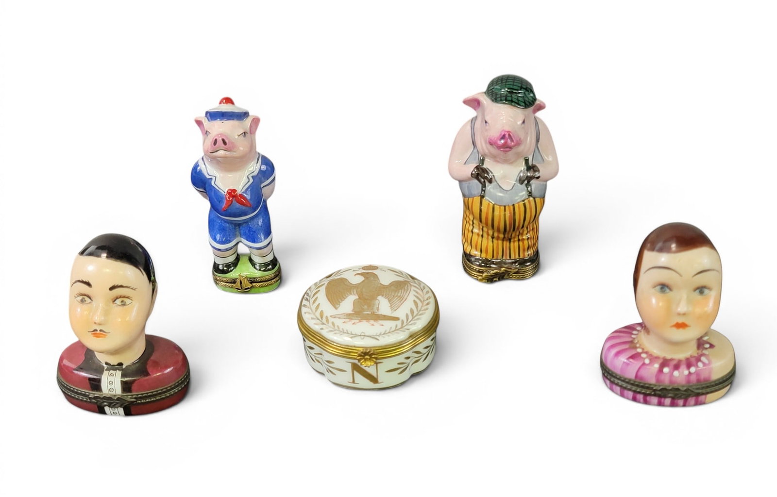 COLLECTION OF FRENCH ENAMELED BOXES: Limoges, 20th century. Includes two pigs, an Art Deco man and woman, and a gilt box with Napoleonic eagle and bees. Tallest is 3.75" high. Provenance: a northeast Ohio collection. NOTE: We are happy