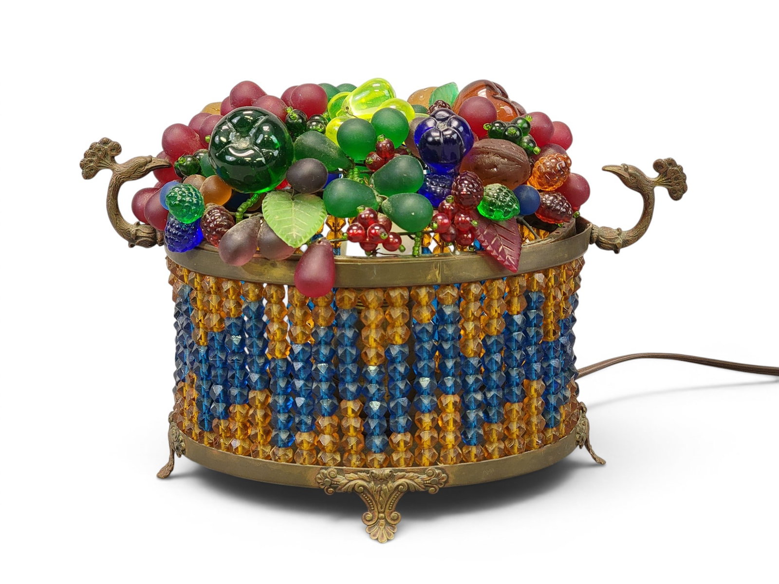 CZECH GLASS FRUIT BASKET LAMP: Marked "MADE IN CZECHOSLAVAKIA", Early 20th century. Patinated frame, the base a beaded basket with bird handles, the top comprising glass fruit and nuts. 7" high, 10.25" long. Provenance: a