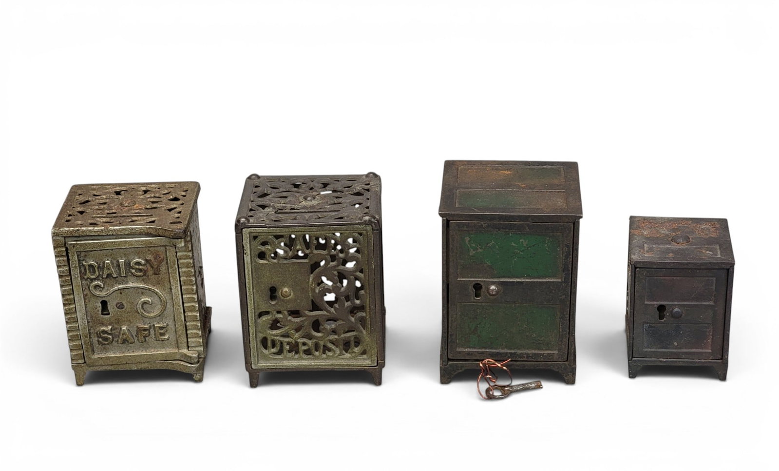 FOUR CAST IRON SAFE BANKS: Includes Columbia Grey Iron Columbia Bank (Moore 878); another but a larger variation (3.625" high); Shimer Toy Co. Daisy Safe variation (Moore 865, but 3 7/16" high); and Shimer Safe Deposit Moore 88