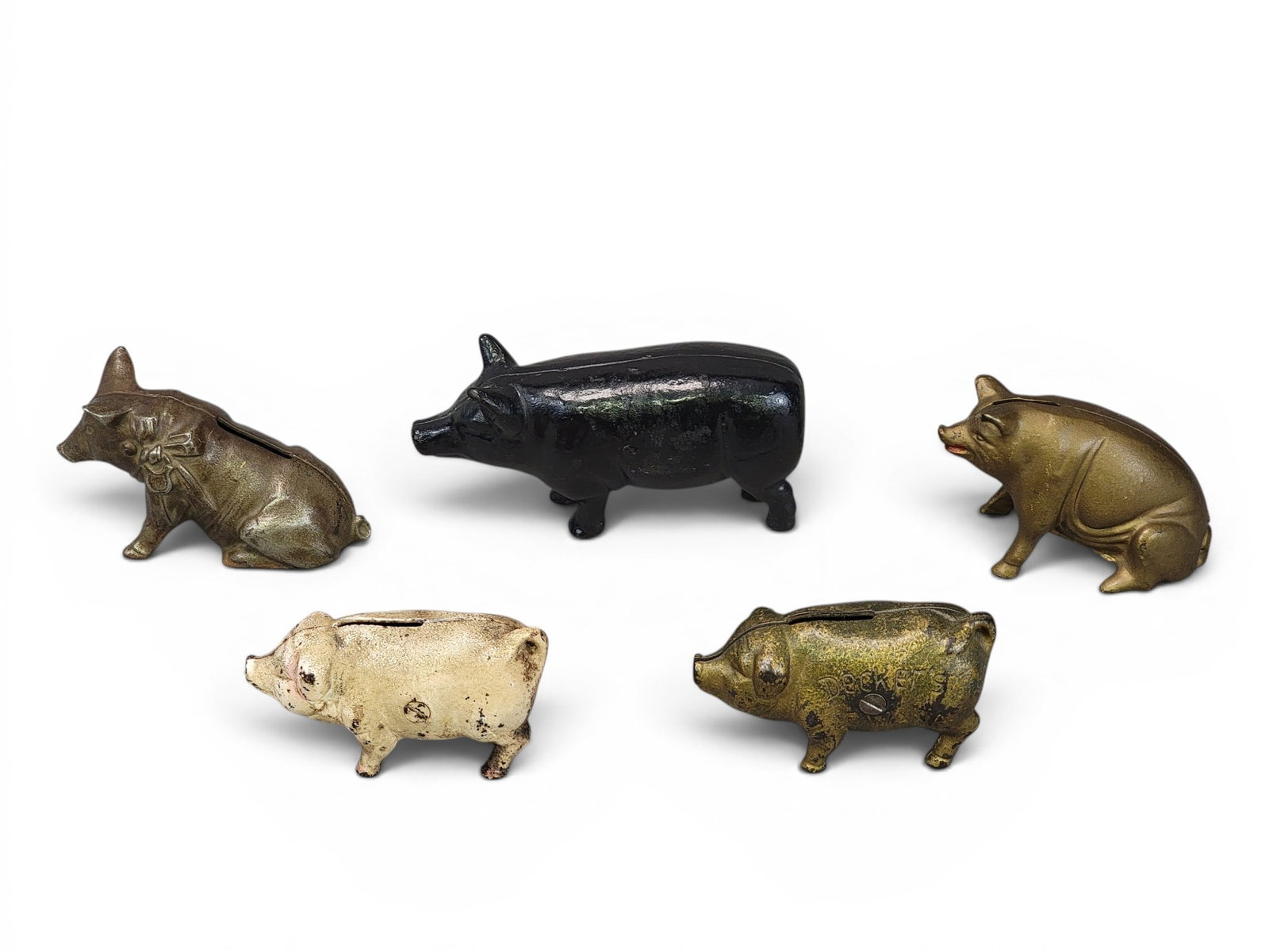 FIVE CAST IRON PIG BANKS: Includes Shimer Toy Pit with Bow (Moore 606); AC Williams Seated Pig (582); Decker's Iowana (Moore 603); John Wright Pink Pig (Moore 607); a standing pig with no tail (not in Moore), 6.25" long. Prove
