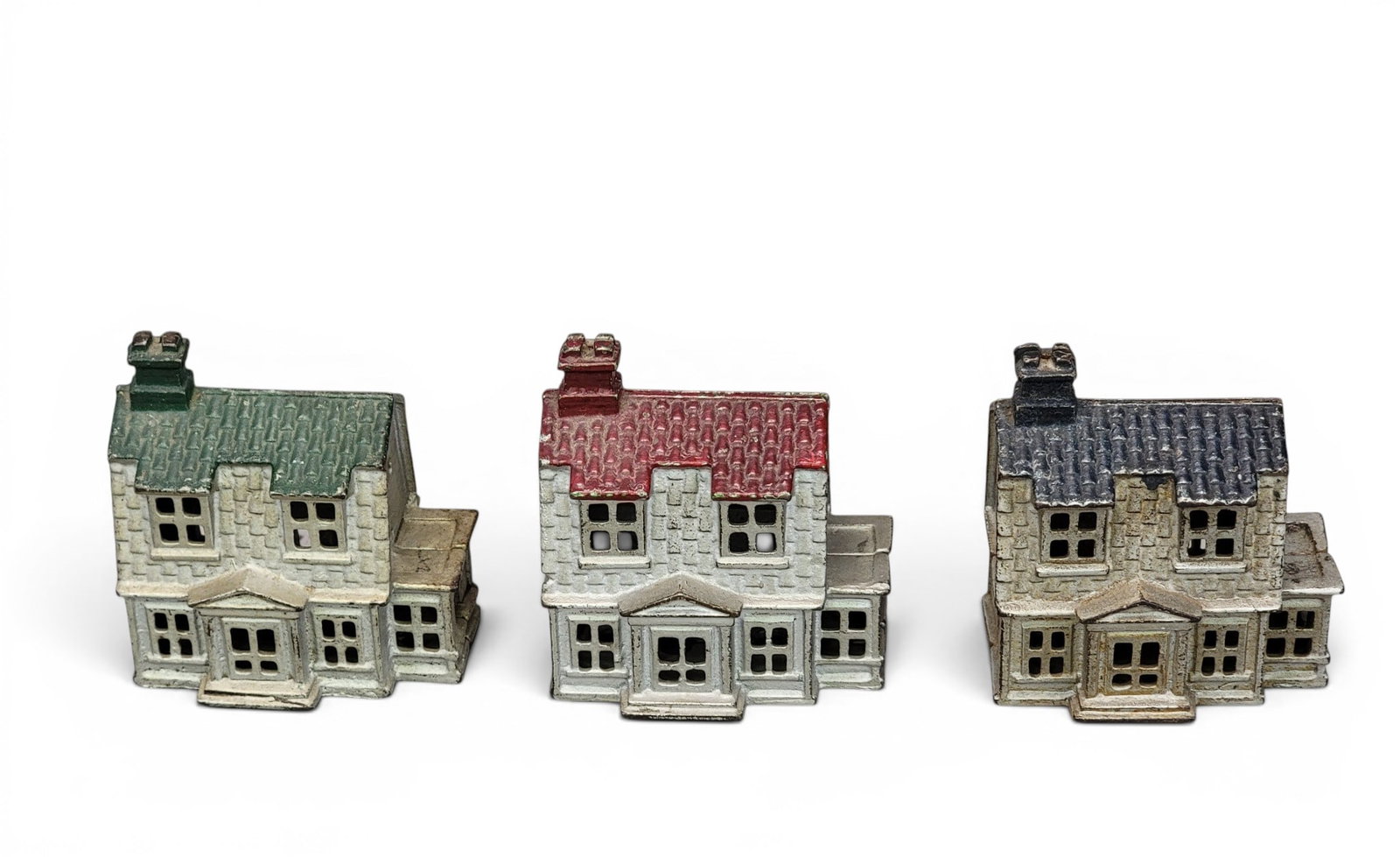THREE CAST IRON HOUSE BANKS: AC Williams, Colonial House with Porch (Moore 992), with three different color roofs. Provenance: a northeast Ohio collection. NOTE: We are happy to answer questions and take additional photos of