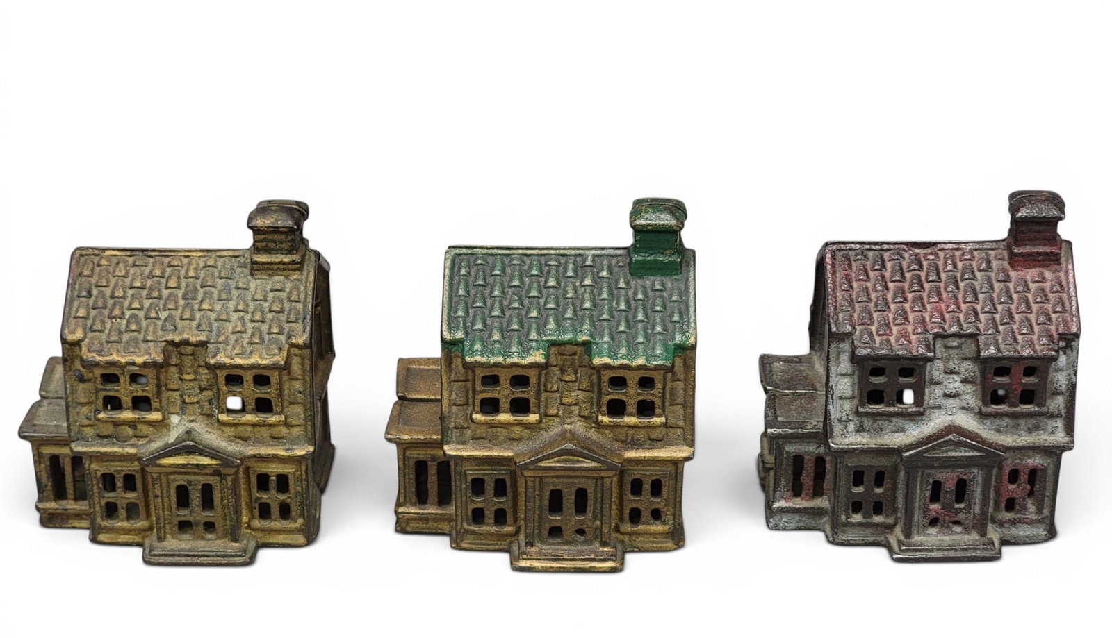 THREE CAST IRON HOUSE BANKS: AC Williams, Colonial House with Porch (Moore 993), with three different color roofs. Provenance: a northeast Ohio collection. NOTE: We are happy to answer questions and take additional photos of