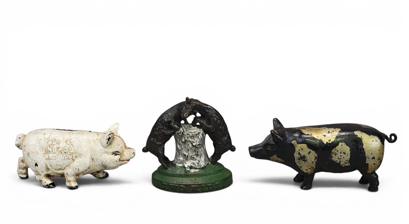 THREE CAST IRON ANIMAL BANKS: Includes Harper(?) Two Kids (Moore 594); together with a standing pig (not in Moore), 7.25" long; and a standing pig with "Buy and Norco and Save," 6" long. Provenance: a northeast Ohio collection. NO