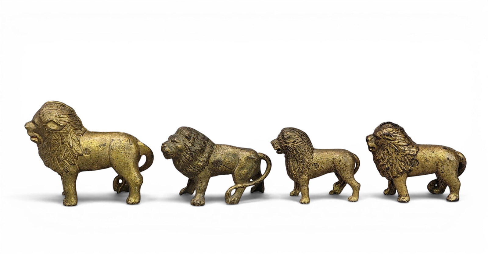 FOUR CAST IRON LION BANKS: Includes AC Williams, Lion Tail Right (Moore 754); two AC Williams, Lion Tail Right (Moore 755); and Hubley, Lion Tail Left (Moore 763). Provenance: a northeast Ohio collection. NOTE: We are happy to 
