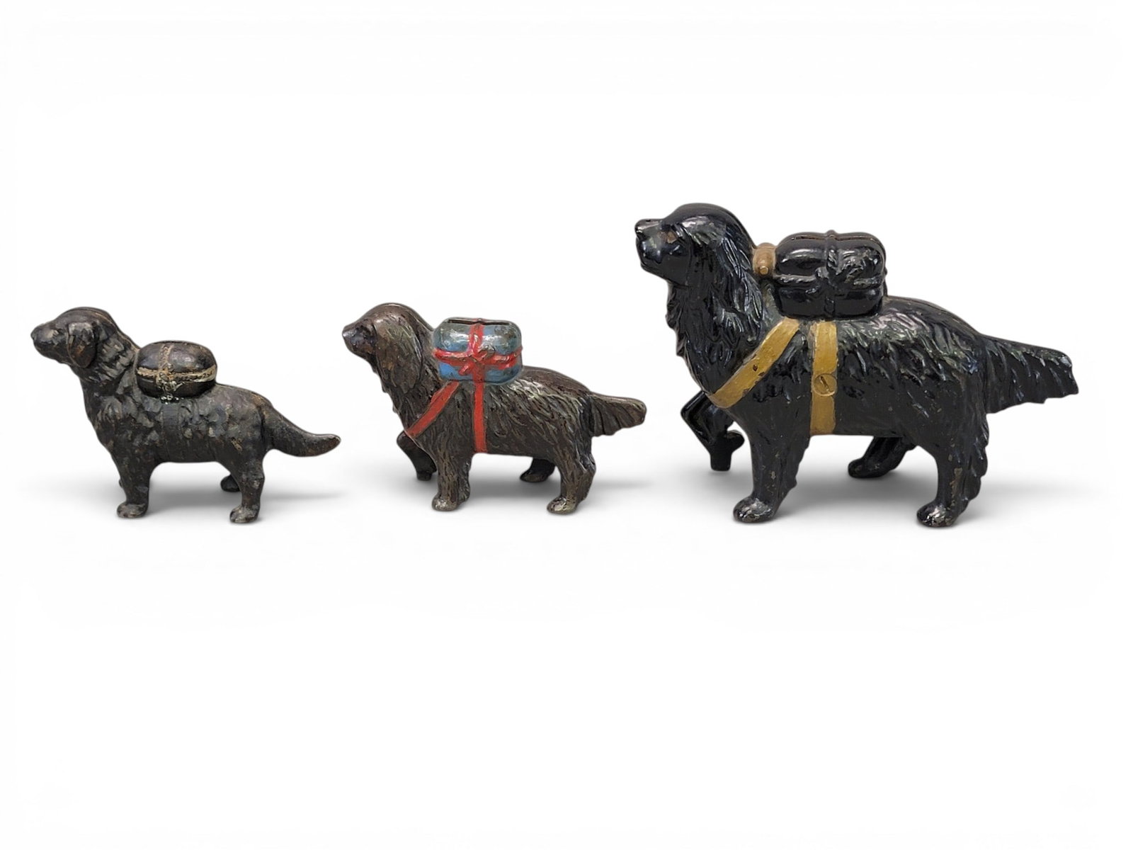 THREE CAST IRON DOG BANKS: Includes Retriever with Pack (1" shorter than Moore 436); together with AC Williams St. Bernard with Pack Large (Moore 437); and AC Williams St. Bernard with Pack Small (Moore 439). Provenance: a nort