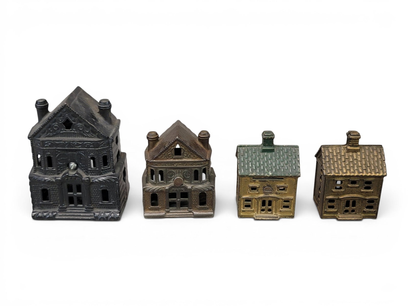 FOUR CAST IRON HOUSE BANKS: Includes J&E Stevens Victorian House Large and Small (Moore 1142 and 1143); togeth with AC Williams Two Story House (Moore 1002). Provenance: a northeast Ohio collection. NOTE: We are happy to answer 