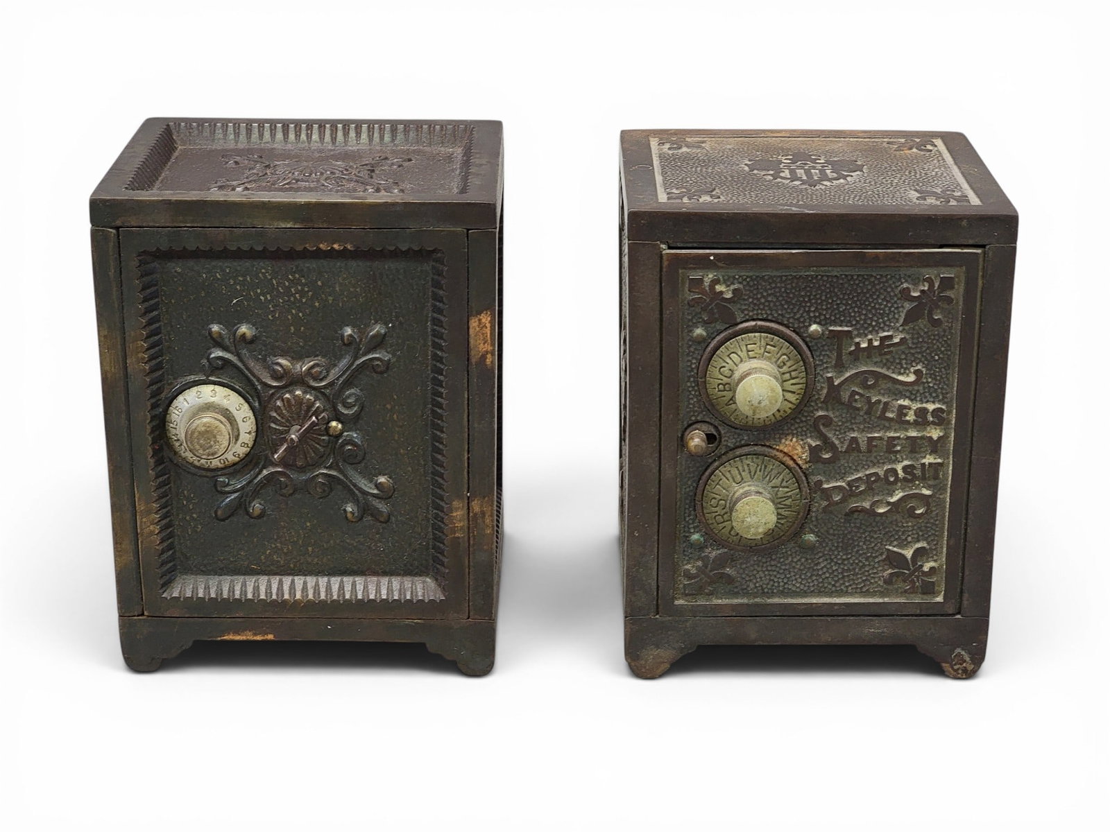 TWO CAST IRON SAFE COMBO BANKS: Includes The Keyless Safety Deposit bank, 5.75" high; together with copper accented safe (with combination). Provenance: a northeast Ohio collection. NOTE: We are happy to answer questions and take ad