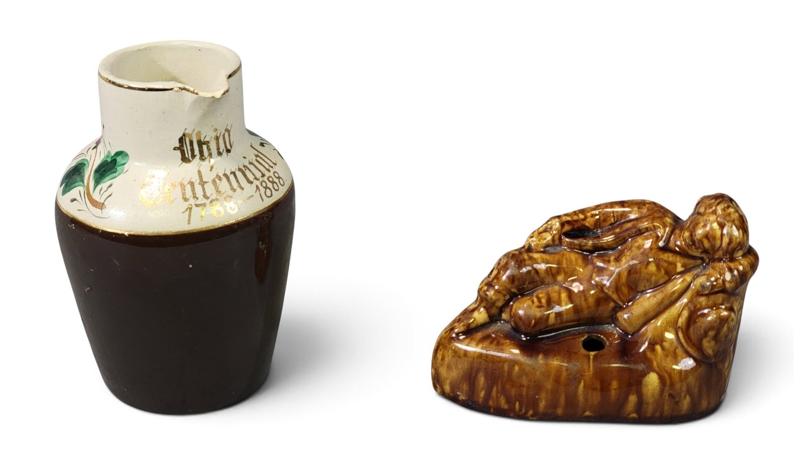 TWO PIECES OF OHIO POTTERY: Includes a Larkin Brothers, East Liverpool figural inkwell, mid-19th century, 5" long; together with a Sherwood Brothers, New Brighton, PA pitcher made to celebrate the centennial of the Northwest