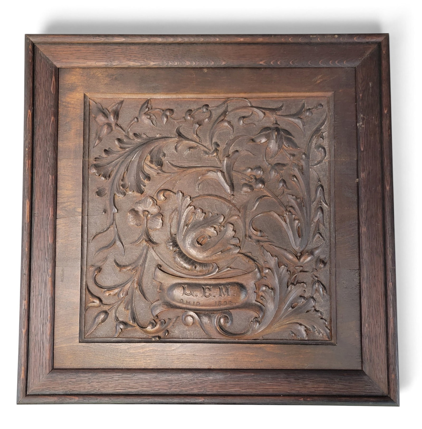 OHIO ART CARVED PANEL: Lydia E. Miller, Urbana, dated 1892, walnut. Square panel with relief-carved design of acanthus leaves and flowers, signed at the bottom "L.E.M. OHIO 1892." 23" high, 23.75" wide. On the back is a