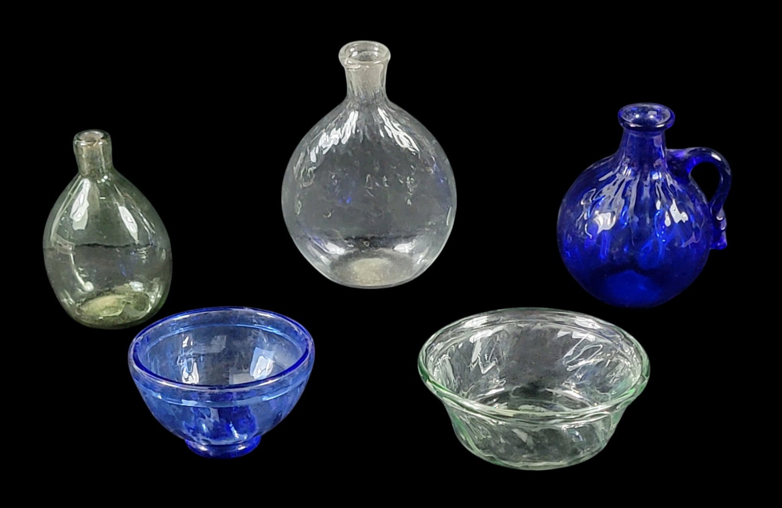 FIVE PIECES OF REPRODUCTION BLOWN GLASS: Hale Farm and Village, Bath, Ohio, 1970s. Includes a cobalt, ribbed, handled jug, 5" high; a cobalt ribbed bowl, 4" diameter; a colorless quilted flask, 7" high; a pale aqua ribbed bowl, 5" diameter;