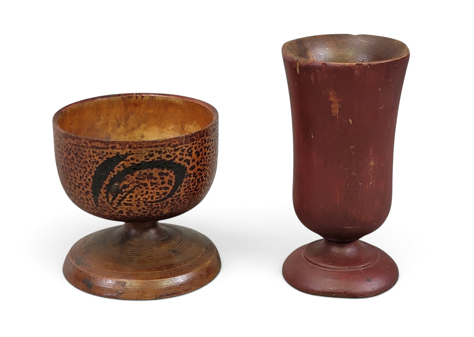 TWO TREEN GOBLETS: 19th century, maple. Includes a slender goblet with original red wash, 5" high; together with a squat goblet with original floral painted decoration, 3.5" high. Provenance: an Ohio collection. NOTE: